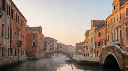 Venetian canal with traditional colorful facades and authentic residential district at golden hour